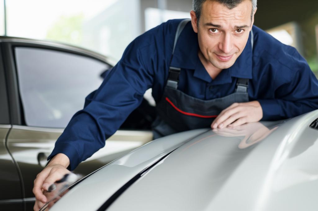 Experienced driver inspecting car paintwork for imperfections